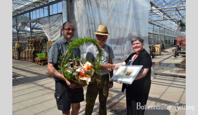 Beatrice Fischer-Duttine &uuml;berreicht an Joachim Struck ein Anerkennungszertifikat und Wolfgang Fischer steht schon mit einem gro&szlig;en Pr&auml;sentkorb bereit.&nbsp;&nbsp; Foto: hz