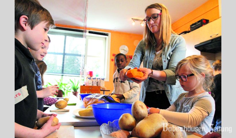Vor dem Essen kommt die Vorbereitung der frischen Zutaten. Corinna Weimer (stehend) zeigte den Kindern, die am Osterferien-Special der Babenh&auml;user Jugendf&ouml;rderung teilnahmen, wie es geht.