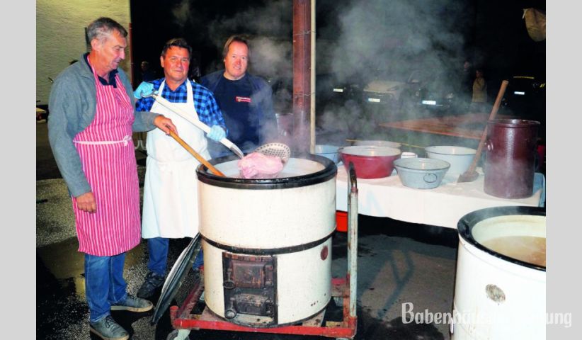 Die Metzger Herbert Mohr und Friedel Scheuermann holen mit Vorsitzendem Norbert Kolb das Fleisch aus den dampfenden Kesseln im Hof der Feuerwehr.