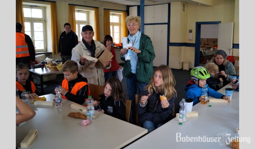 Friedel Sahm und Hanna Cordier verteilen beim Mittagessen die Geschenke an die kleinen Helfer: Mehrwegbecher und eine Stiftebox setzen auf Nachhaltigkeit und freuen die Kinder.